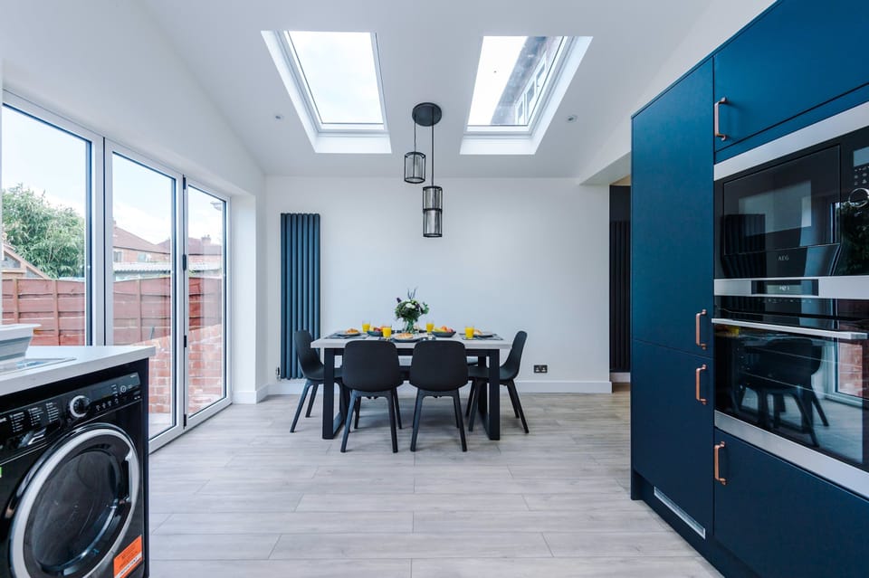 Modern kitchen extension with bold blue tones and plenty of worktop space for preparing meals during your stay