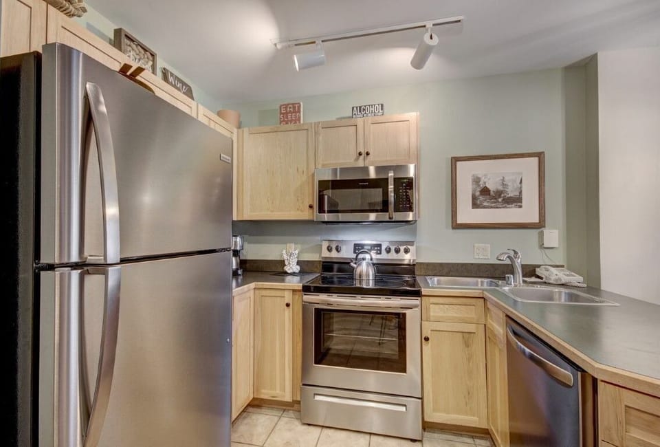 Sleek kitchen featuring stainless steel appliances and warm wood cabinetry, blending modern comfort with alpine charm.