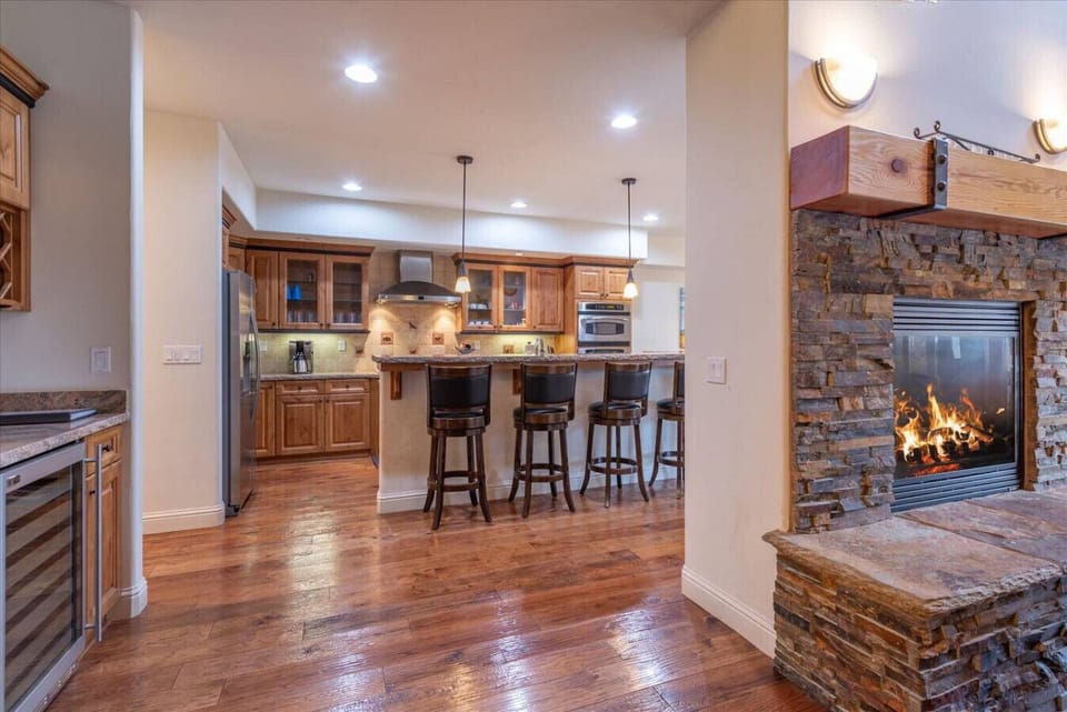 Spacious great room (living room, dining area, kitchen) with vaulted ceilings, see through gas fireplace, 65 inch SmartTV and comfortable furnishings.