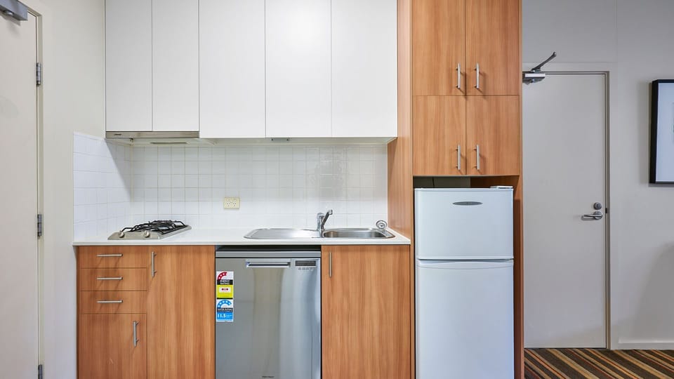 Compact kitchen with fridge, stove, and ample storage