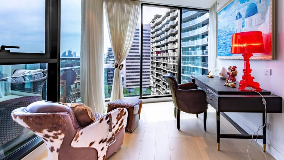 Bright corner work space with floor-to-ceiling views and cozy seating.