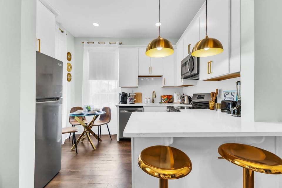 COOK & CREATE! Fully equipped modern kitchen with stainless steel appliances. Turn family meals into vacation feasts! Gold accents throughout. Book your Savannah stay! #ModernKitchen #FamilyFriendly