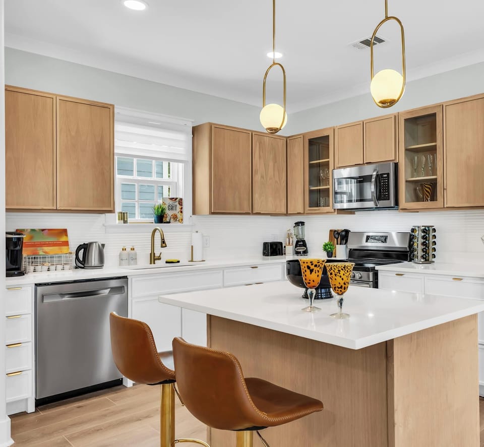 MODERN KITCHEN: Fully stocked with gold accents & new appliances! Turn meal prep into vacation delight! Coffee maker, dishwasher, family-friendly. Book now! #ModernKitchen #SavannahStay