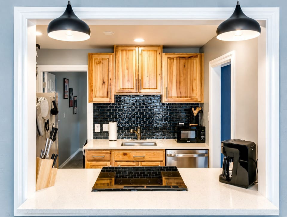 Bright modern kitchen with breakfast bar, cooktop, and coffee station
