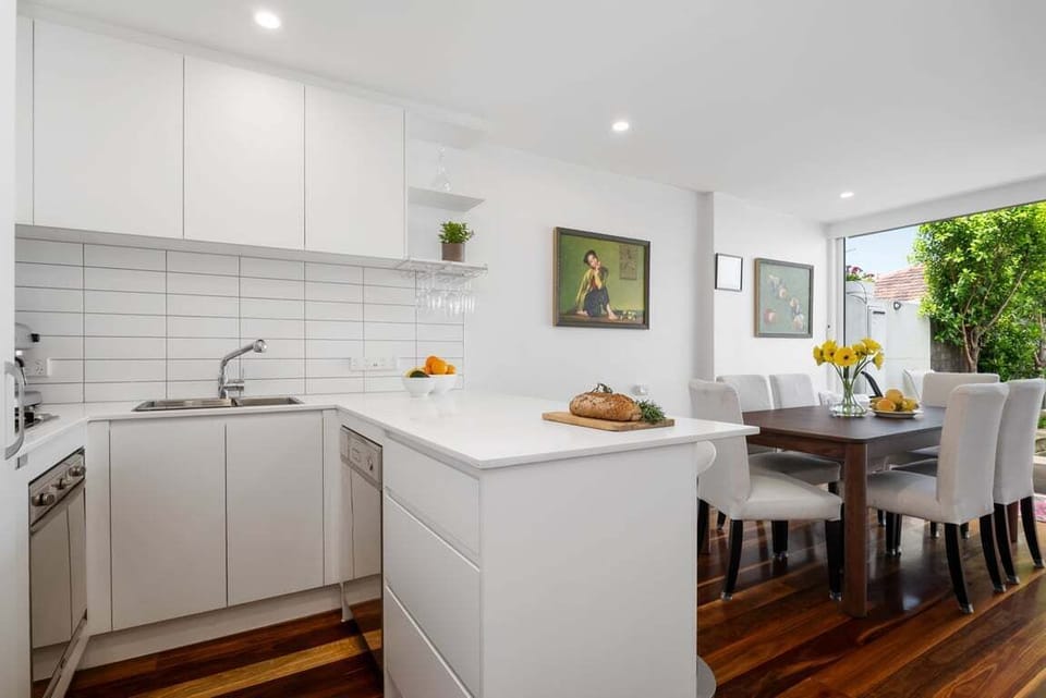 KITCHEN: The contemporary kitchen has all the needed appliances, a stone benchtop with stools and a stocked basic pantry.
