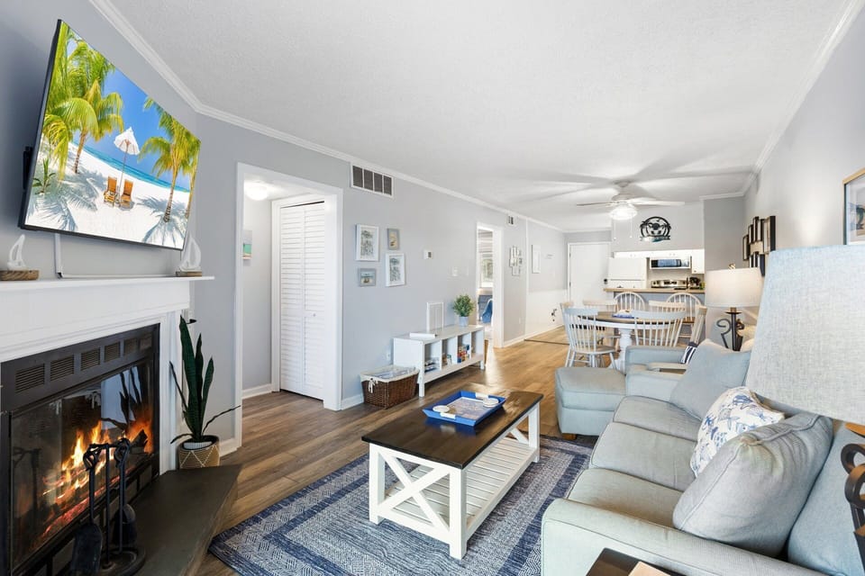 The bright and inviting living area features new LVP flooring, fresh paint, and stylish coastal décor for a clean, modern feel.