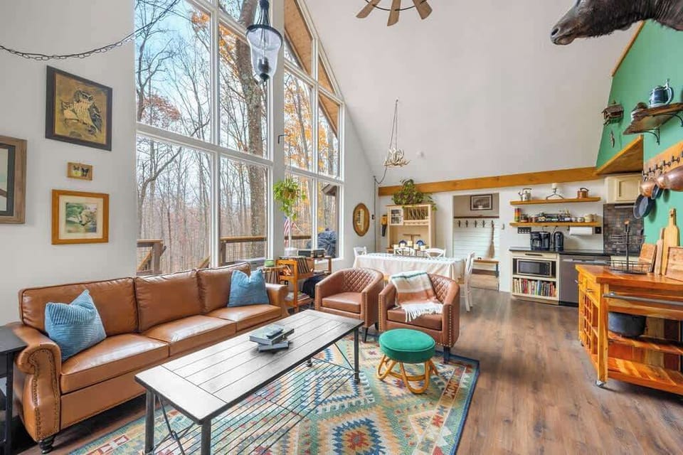Spacious, light-filled gathering space with floor-to-ceiling windows and woodland scenery.