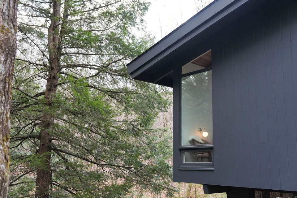 Single-level mid-century masterpiece perched above the rushing Clay Brook