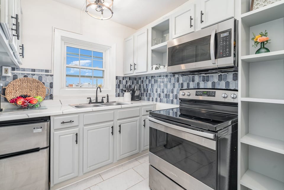 Essentially equipped kitchen, complete with stainless-steel appliances and a dining area for 2 guests.