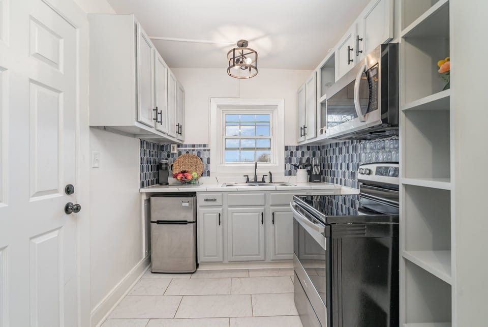 Essentially equipped kitchen, complete with stainless-steel appliances and a dining area for 2 guests.