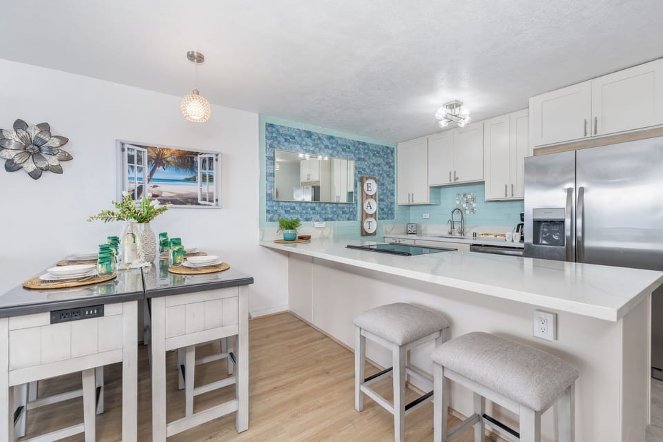 Stylish dining space with seating for four, complemented by coastal-inspired accents and open layout.