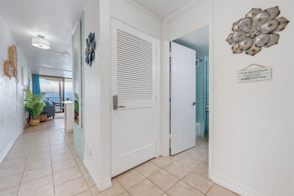 Welcoming entryway featuring coastal artwork and light, airy design for a relaxing island feel.