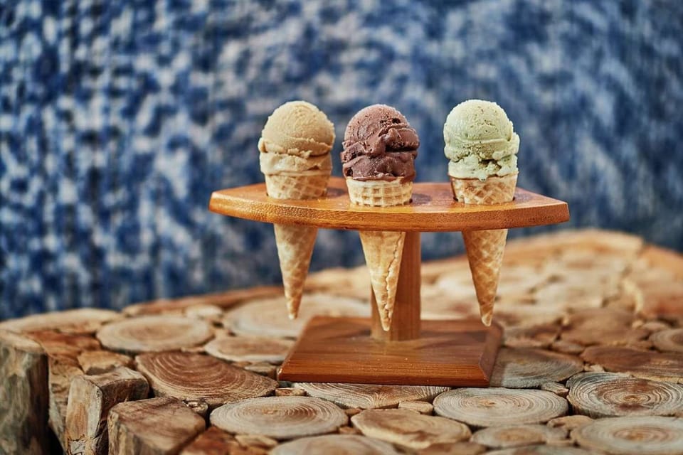 Three ice cream cones displayed on a wooden stand