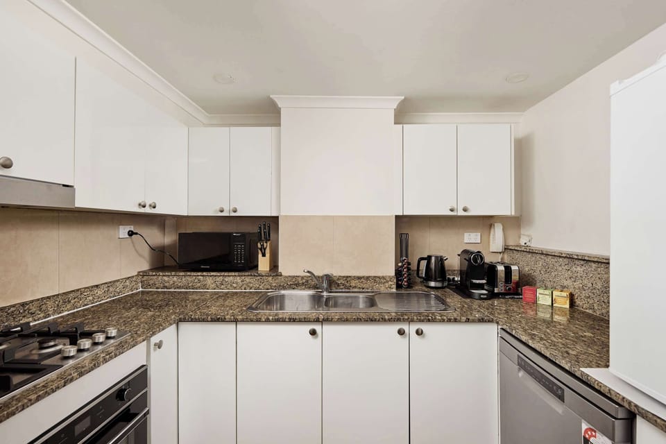 Full Kitchen:
Fully-equipped kitchen with granite countertops, quality appliances including gas cooktop, oven, microwave, and dishwasher. Ample storage and prep space plus Nespresso coffee station for convenient home cooking.