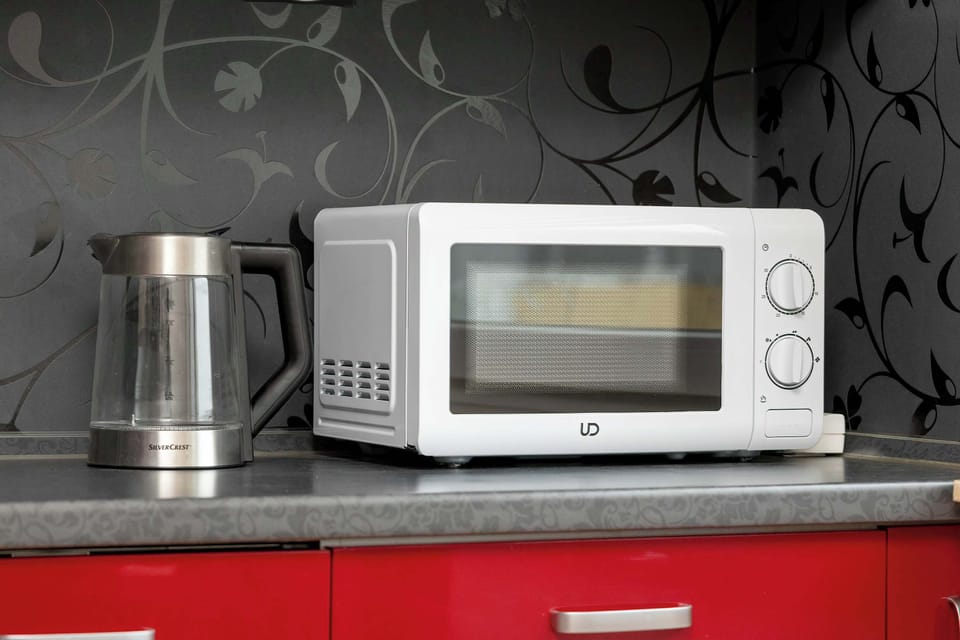 Coffee and tea station with microwave and kettle.