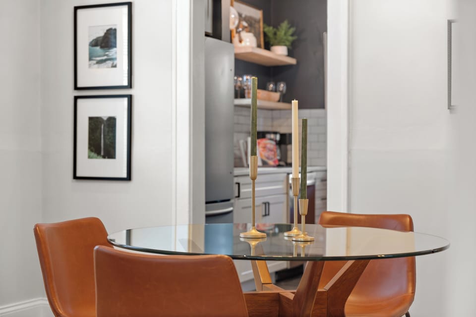 Dining table with seating for four, sideboard cabinet, and desk with chair.