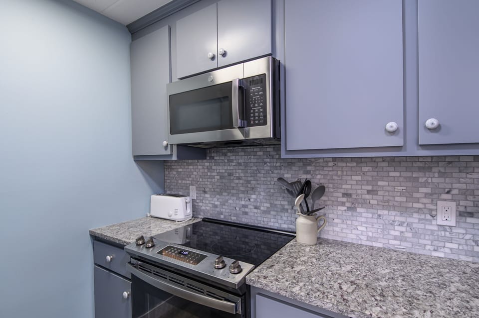 Your fully equipped kitchen features granite countertops, stainless steel appliances, and elegant subway tile backsplash for all your culinary needs.