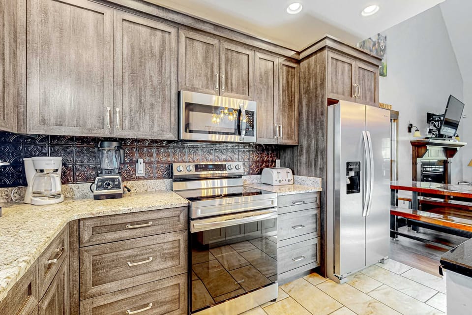 Beautiful cabin kitchen featuring stainless steel appliances, granite-style counters, coffee station, and modern finishes. Everything you need for a comfortable stay.