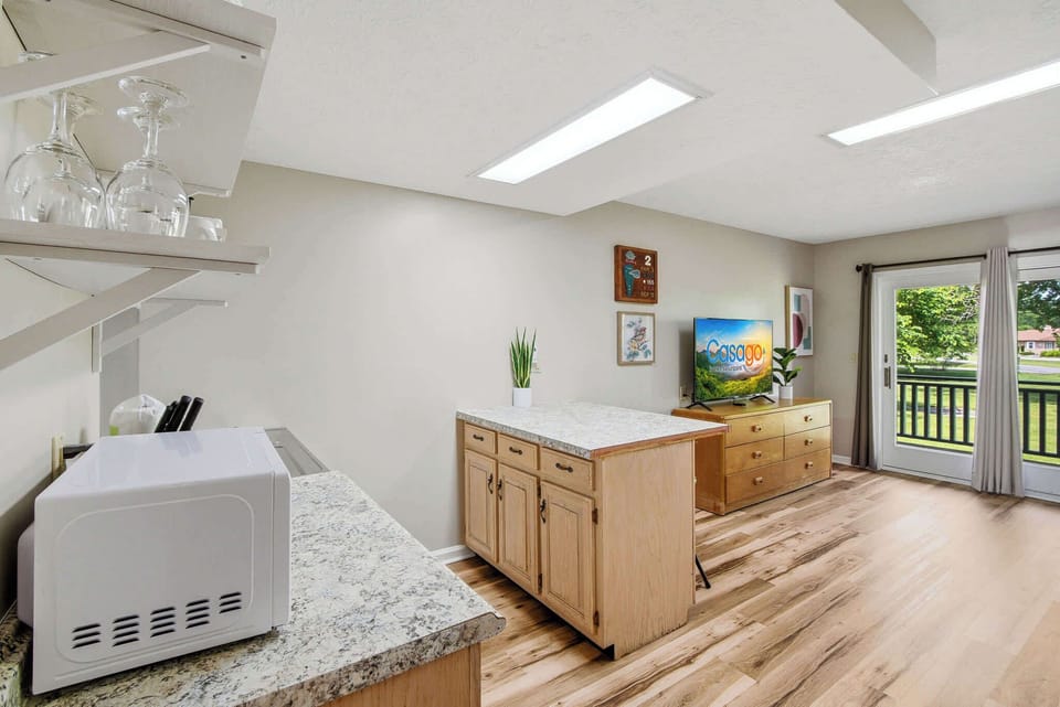 Kitchenette with microwave, sink, cooktop, mini fridge, dishes, and coffee maker. Everything for simple meals. Ideal getaway setup for extended stays, families, and weekend travelers.