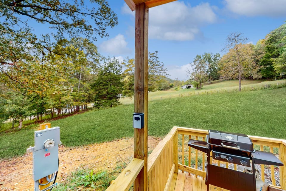 Private deck with BBQ grill and sweeping meadow views. Outdoor dining, cookouts, mountain-country getaway. 
