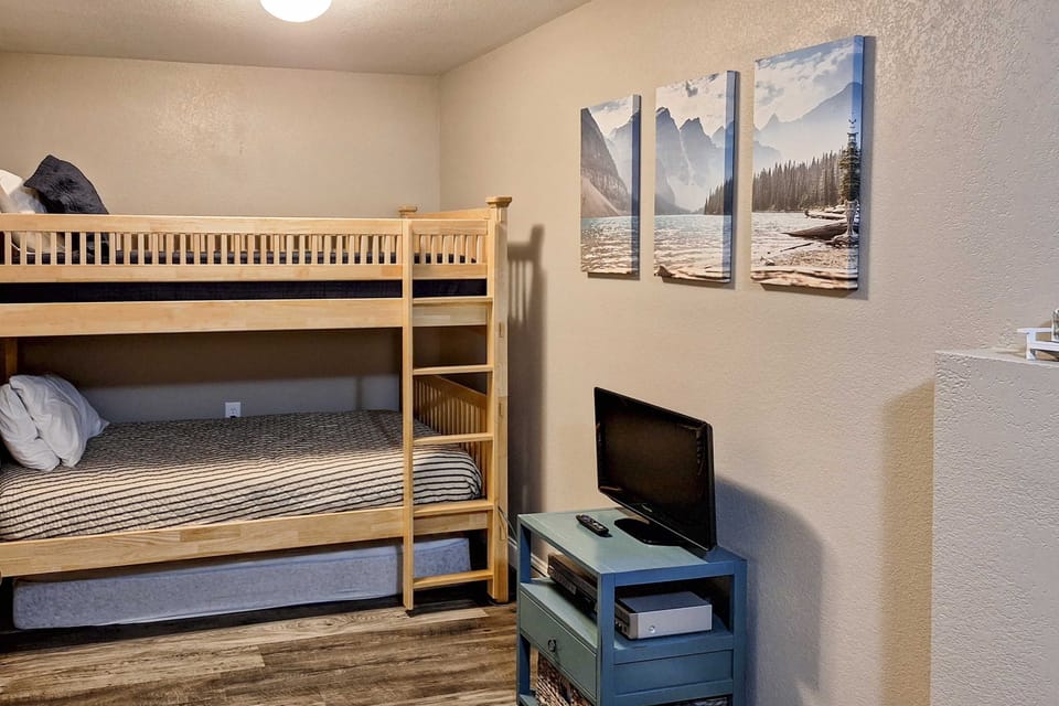Spacious bunk room with twin-over-full bed, TV, and cozy decor. Perfect for families and group getaways; extra sleeping capacity, relaxing space, and great for lake weekends and holiday trips.