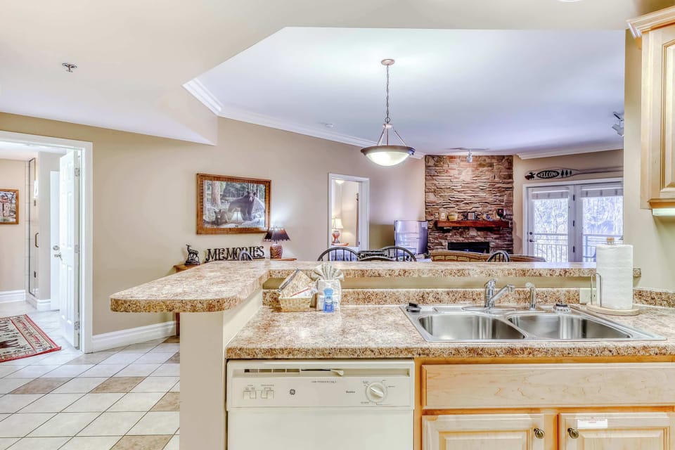 Stylish space with elegant finishes, warm lighting, and a cozy stone fireplace view!