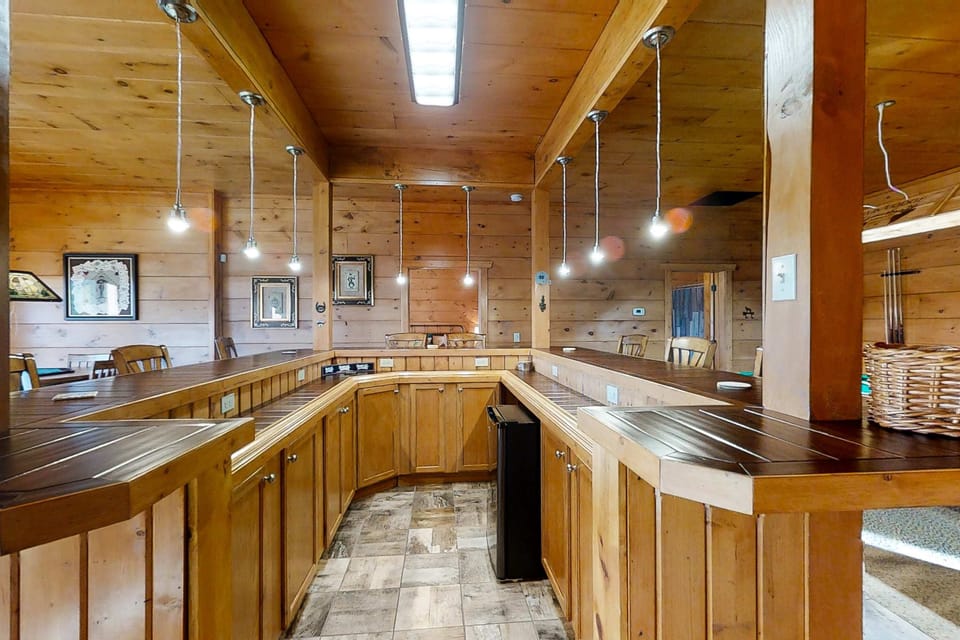 Huge rustic bar and serving area with plenty of seating. Great for entertaining, family meals & group gatherings. Spacious Smoky Mountain cabin Cabin with lodge-style layout.