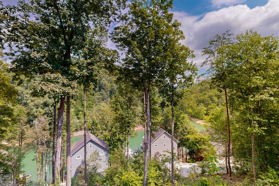 Enjoy stunning lake views and lush forest from this charming hillside getaway!