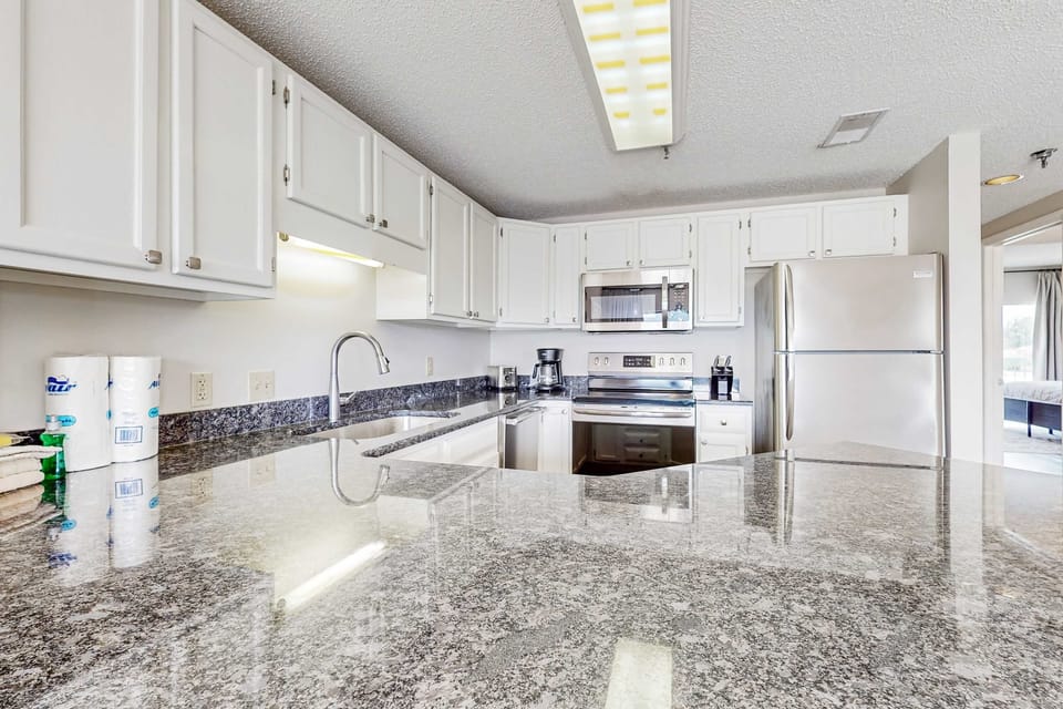 Whip up culinary delights in this sleek, modern kitchen with granite countertops!