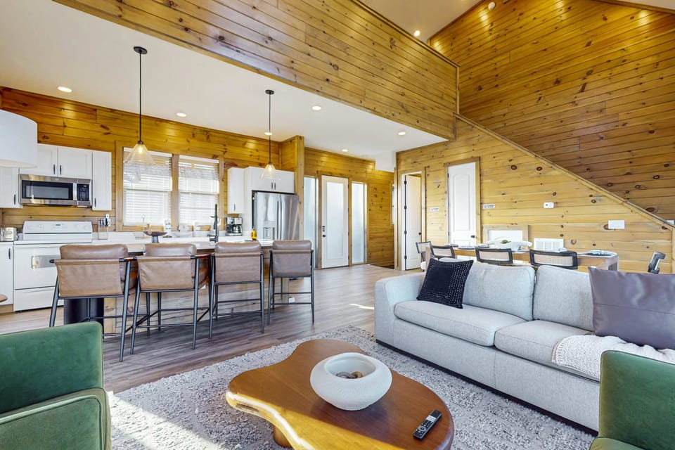 Relax in this open-concept living room with stylish seating, large dining area, and seamless flow to the kitchen. 