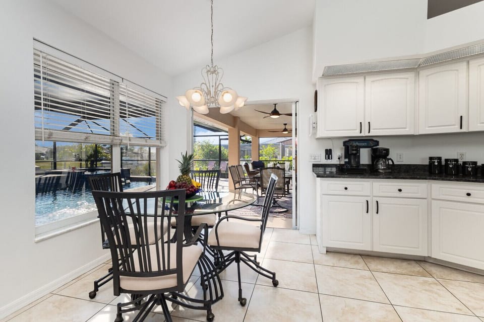 Bright breakfast nook overlooking the pool and lanai. Start your day with coffee, sunshine, and peaceful canal-side vibes.