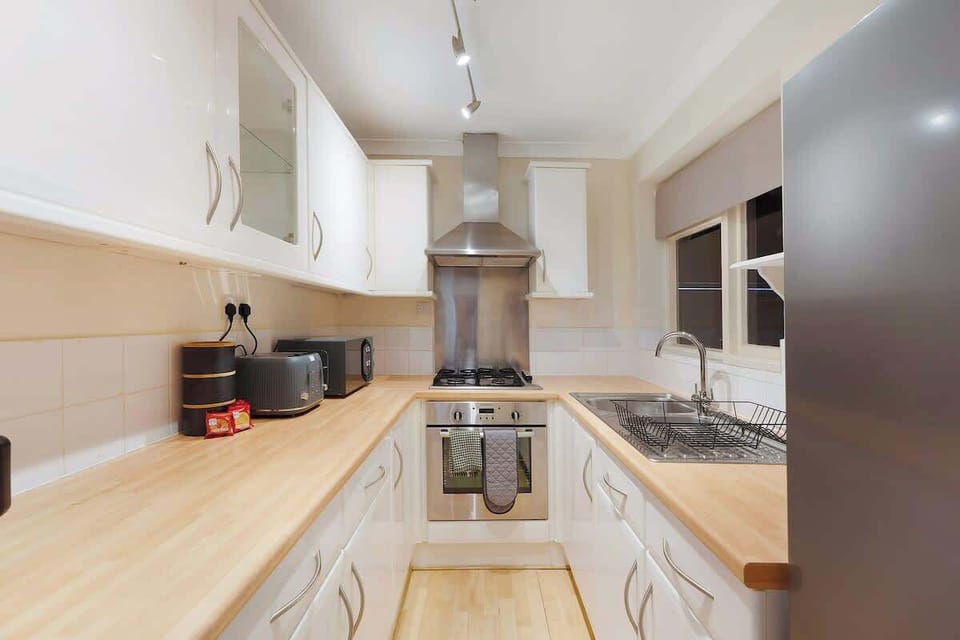 Kitchen equipped with all essentials, including a dryer, oven, fridge and full cookware set.