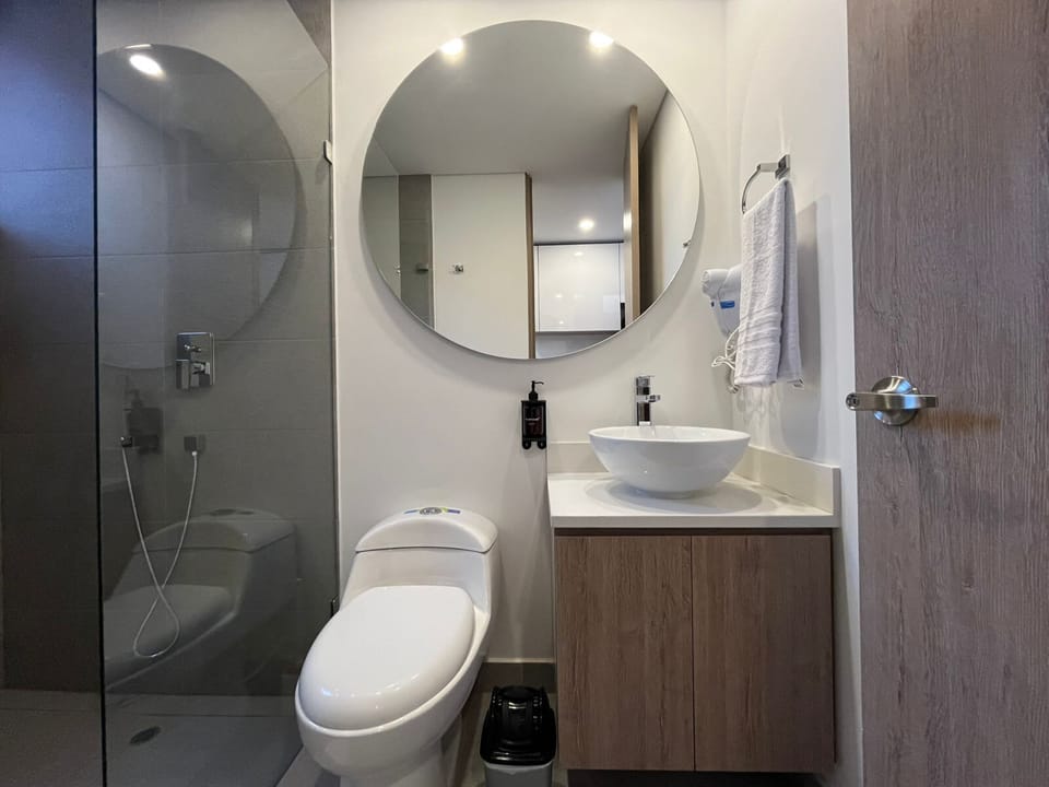 A modern bathroom with a circular mirror