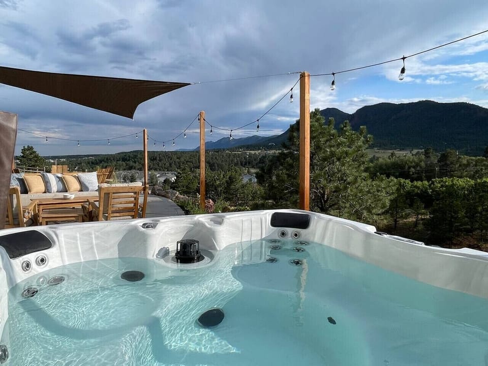 A Full View of the Hot Tub Towards the Mountains and Seating Area with Firepit