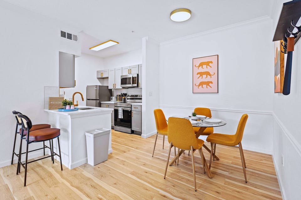 Modern dining area with seating for four and direct access to the kitchen. Perfect for shared meals and work sessions.