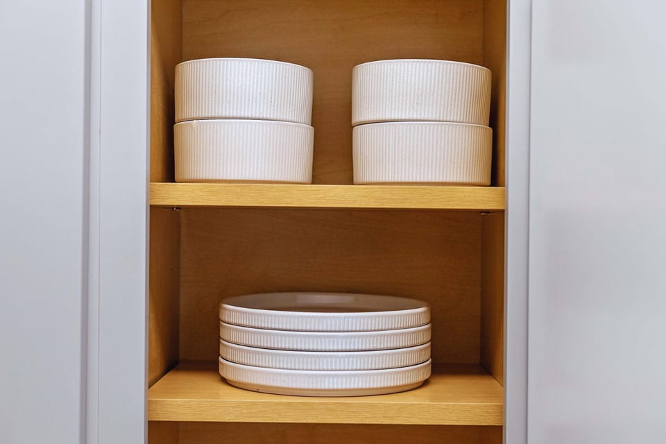 Neatly organized kitchenware with plates and bowls ready for all your meals. Convenient and guest friendly.