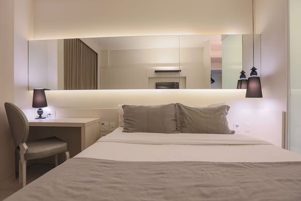 Sink into crisp linens under soft, calming bedside glow.