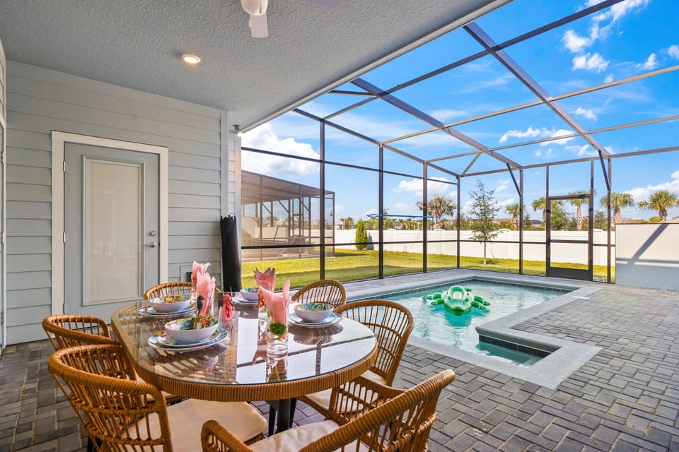 Dine alfresco on the covered lanai with ceiling fan, steps from your private screened-in pool-sunny yard views and a playful float included!