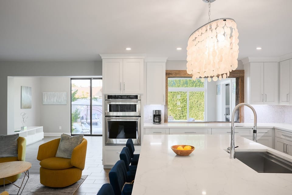 Fully equipped kitchen with stainless steel appliances, a sleek kitchen island with a breakfast bar for casual seating for 4.