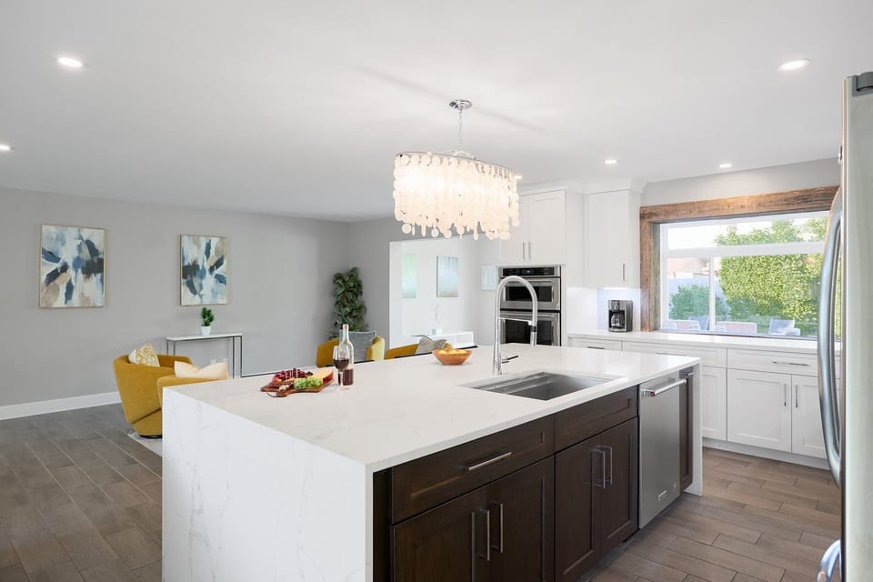 Fully equipped kitchen with stainless steel appliances, a sleek kitchen island with a breakfast bar for casual seating for 4.