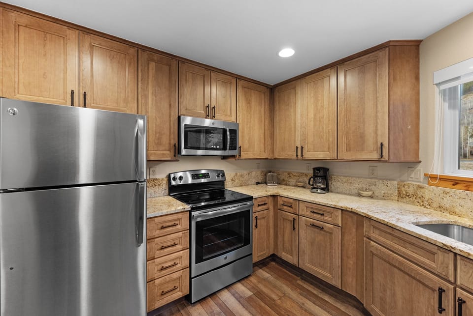 Your fully equipped kitchen features warm wood cabinets, granite counters, and stainless steel appliances—perfect for preparing meals during your stay.