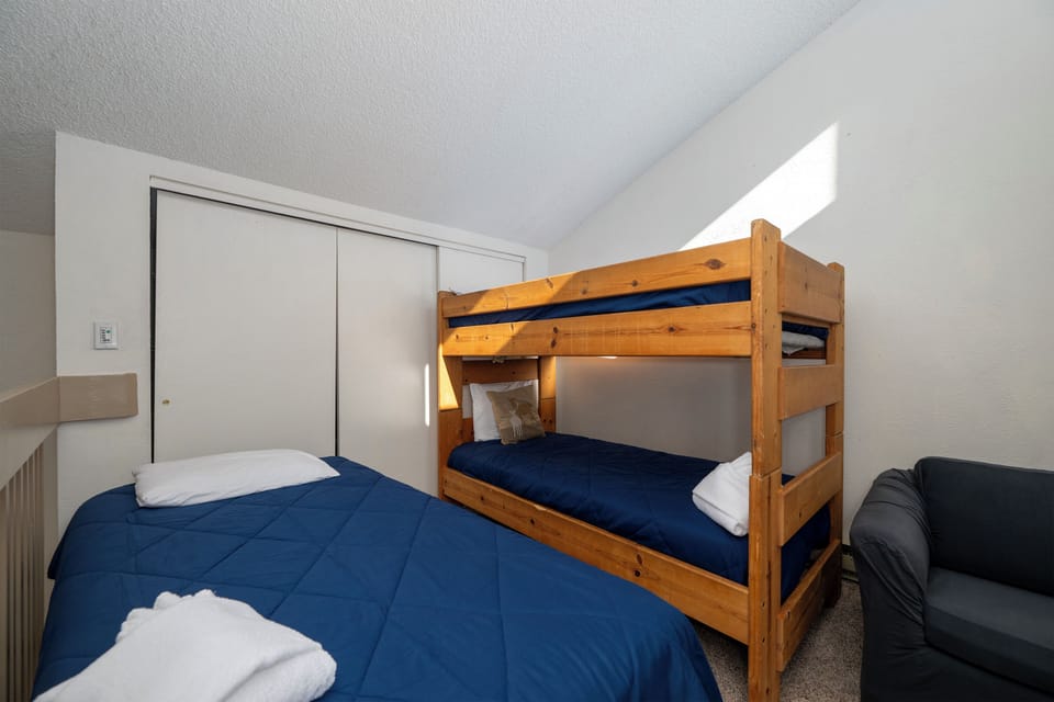 Cozy bedroom with bunk beds and single bed—perfect for families or groups. Fresh linens and comfortable seating create your restful retreat.