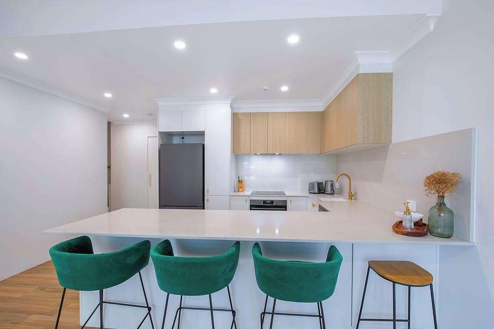 The open kitchen’s breakfast bar doubles as the main dining area, offering a casual space for shared meals.