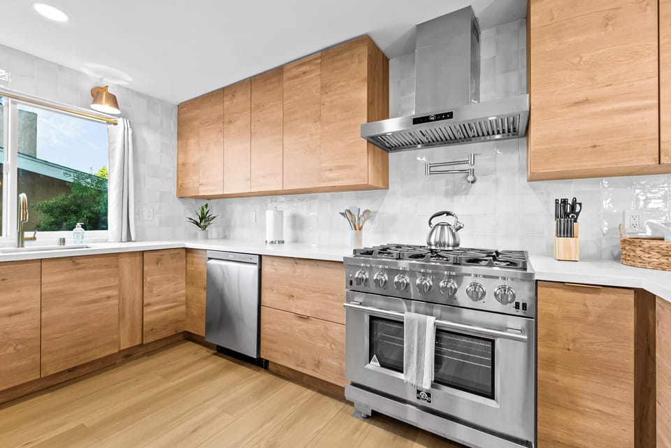 Modern kitchen with wood cabinets and stainless-steel appliances.