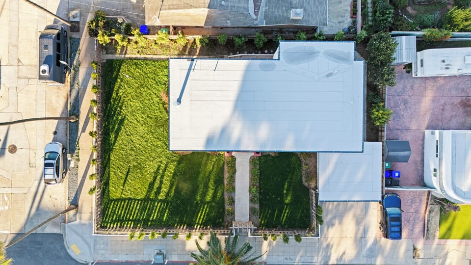 Overhead view of the home’s roof and green backyard.