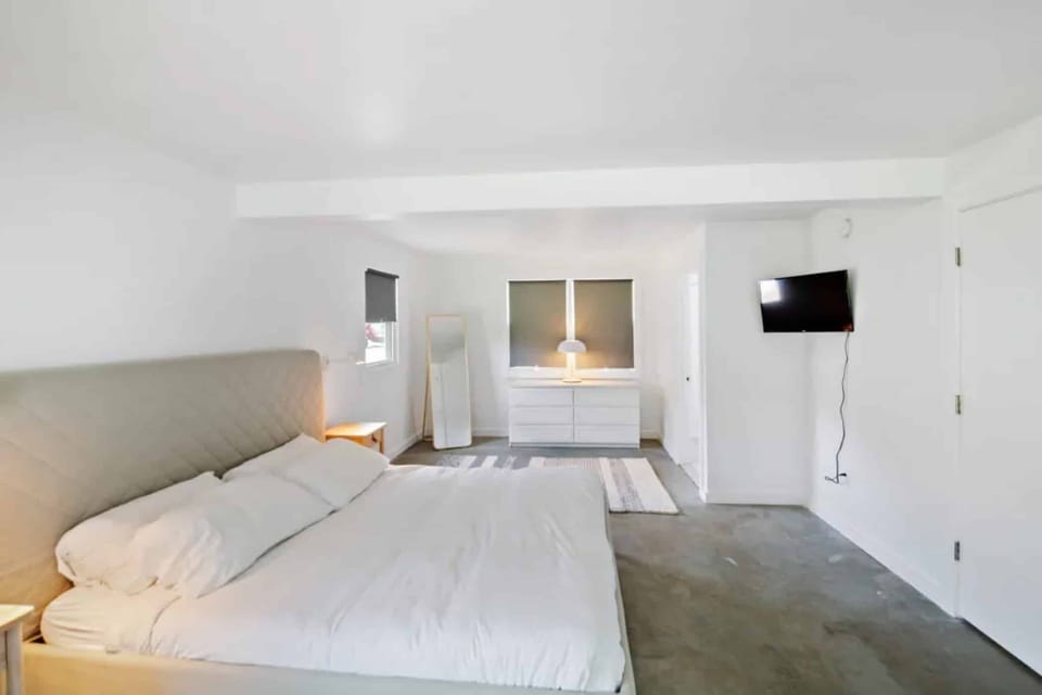 Unwind in a spacious bedroom with soft lighting and calm tones.