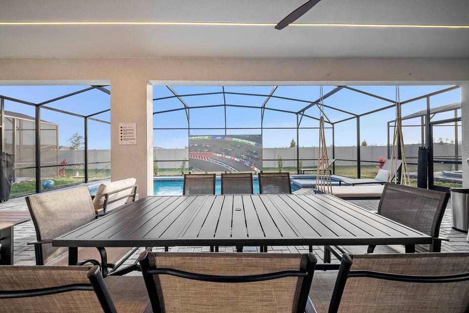 Enjoy meals al fresco on the spacious patio with a stylish dining table, overlooking the serene pool. A modern ceiling fan adds comfort, making this the perfect spot for relaxation and unforgettable moments.