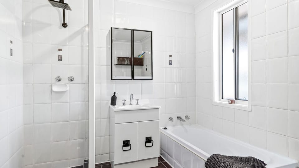 Clean, modern bathroom featuring a bathtub and walk-in shower