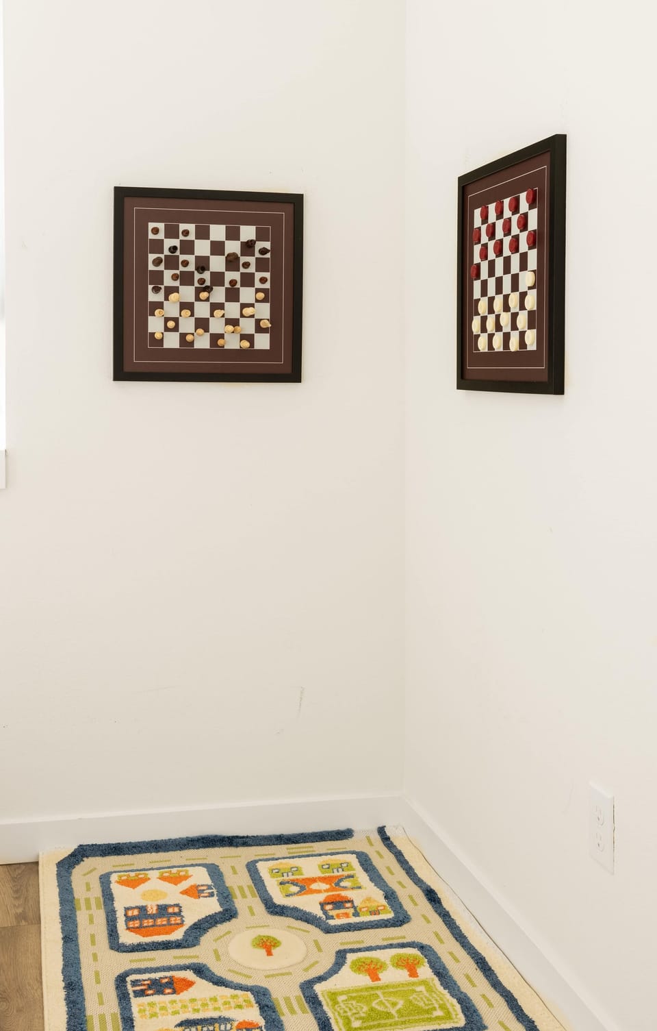 A fun play corner with framed game boards and a colorful rug. Ideal for quiet playtime or games with friends.
