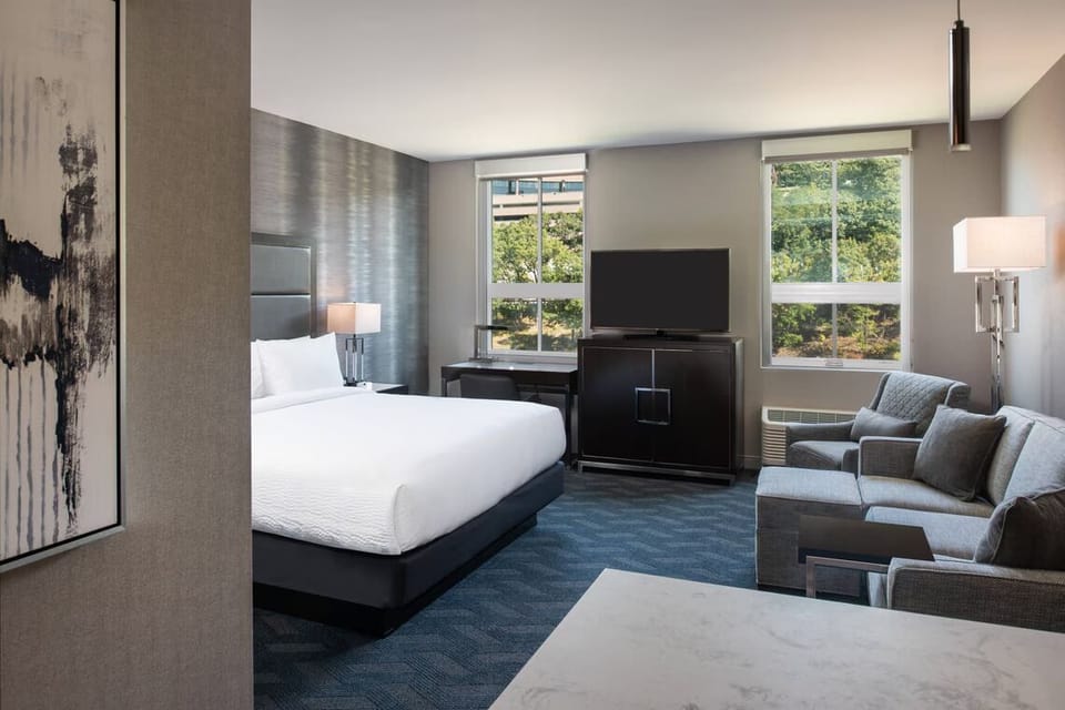 Unwind in a sunlit studio bedroom with plush king bed.